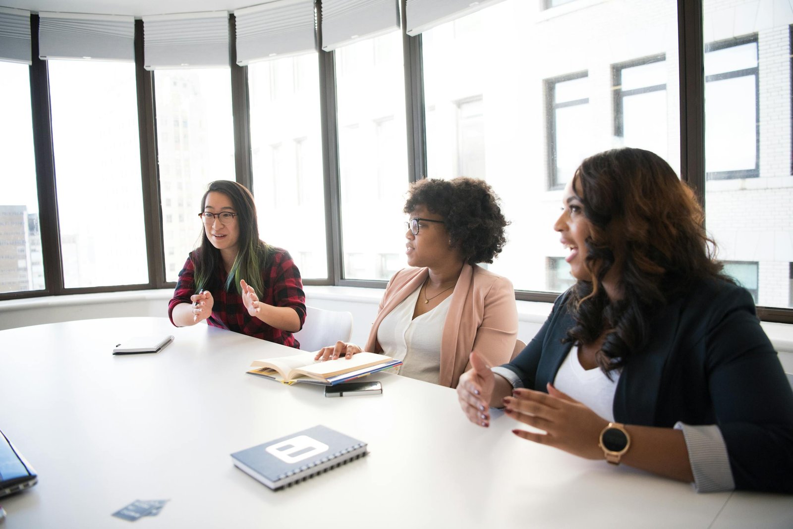 Three businesswomen engaging in a productive meeting inside a modern office space.